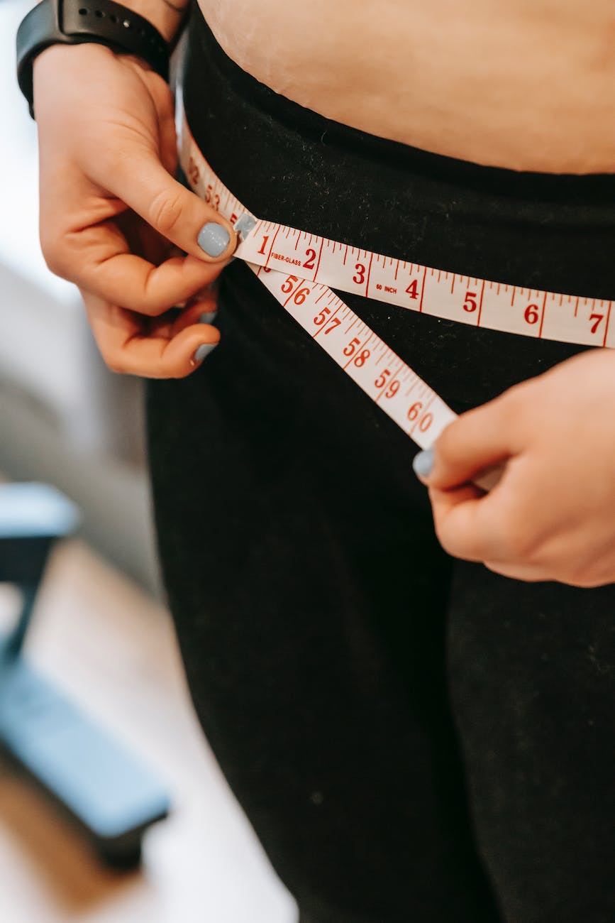 Picture of an individual measuring their waistline. 